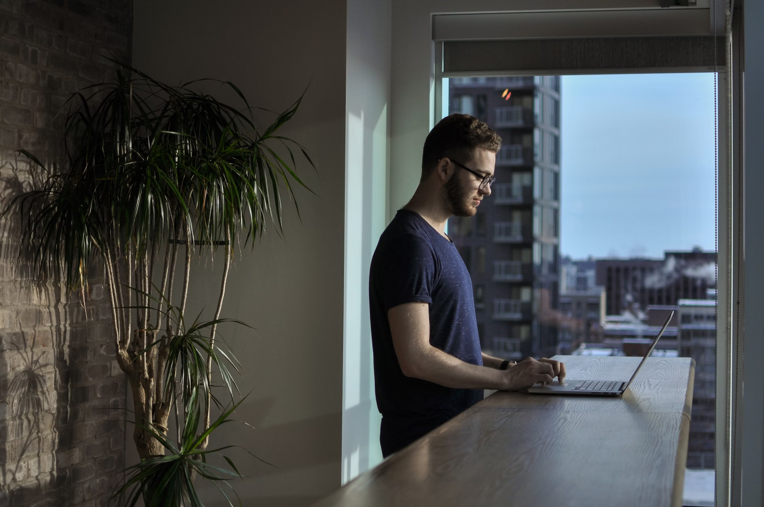 Person at standing desk working on laptop